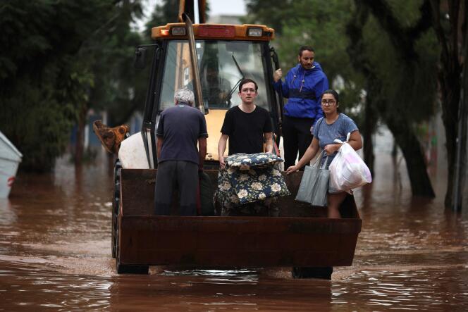 Des personnes sont évacuées d’une zone inondée à l’aide d’une chargeuse compacte dans le quartier de Sao Geraldo à Porto Alegre, dans l’Etat du Rio Grande do Sul, au Brésil, le 4 mai 2024. 